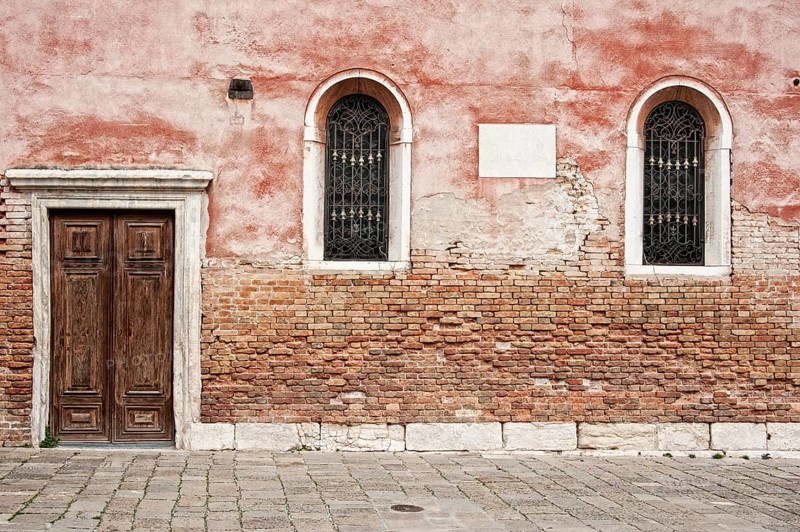 Red house wall with windows and doors in the San Polo district