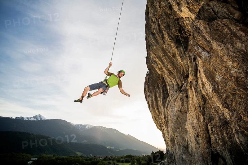 Climber hanging on the rope by the cliff