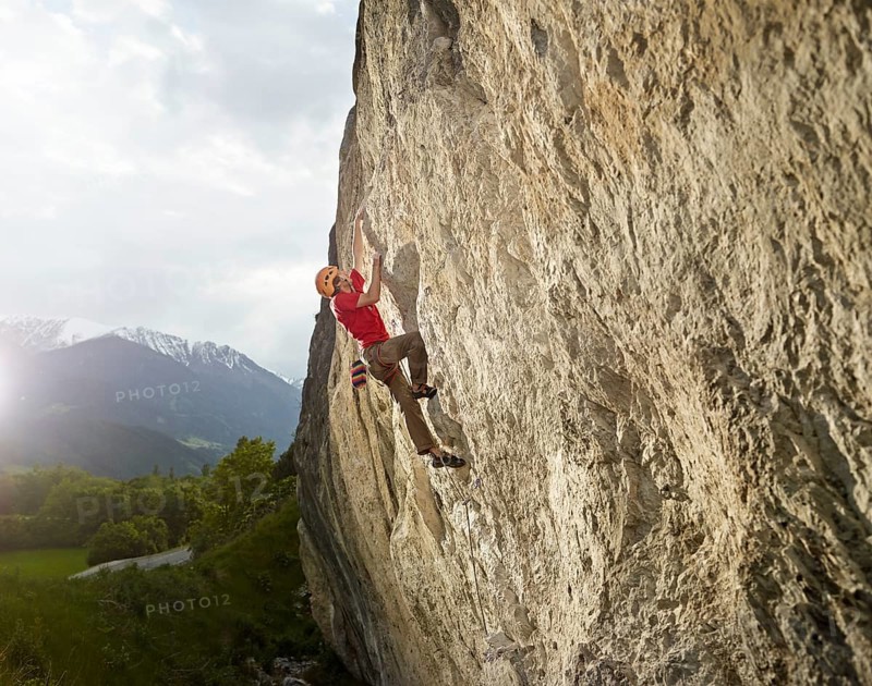 Climber lead climbing on a rock face