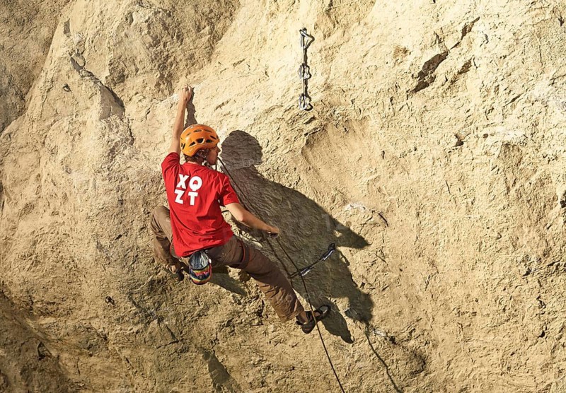 Climber lead climbing on a rock face