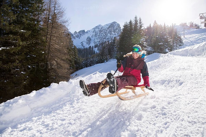 Young woman riding on a sledge