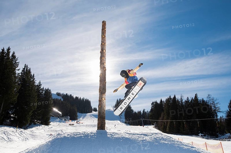 Teenage snowboarder jumping in a funpark