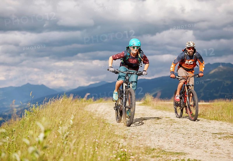 Two mountain bikers with helmets riding on gravel roads