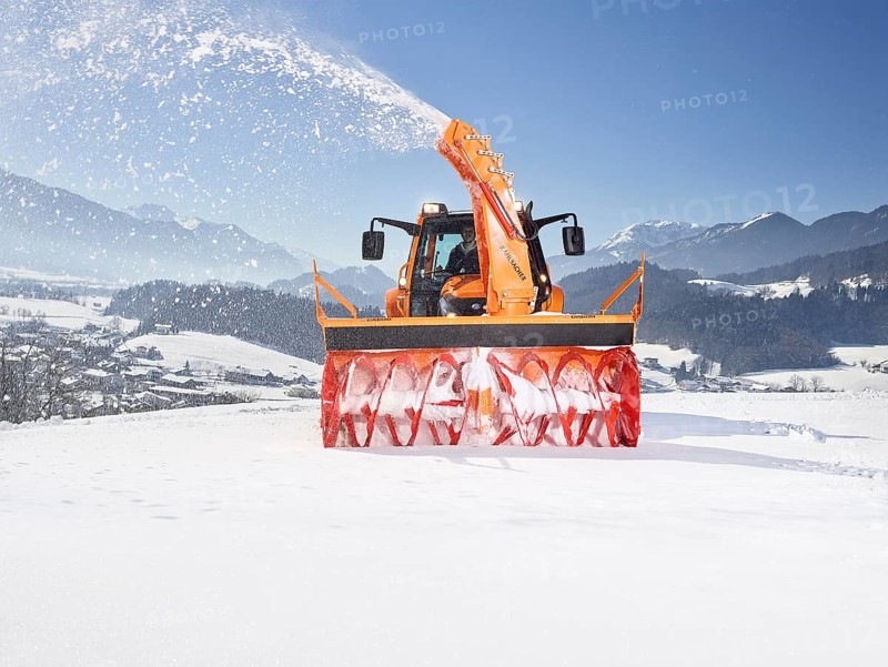 Tractor with a snow blower clearing snow