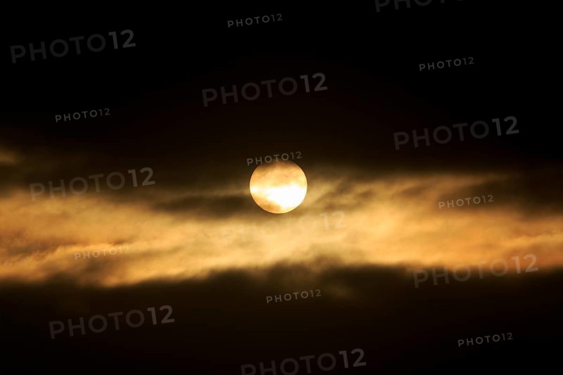 Sun between dark clouds