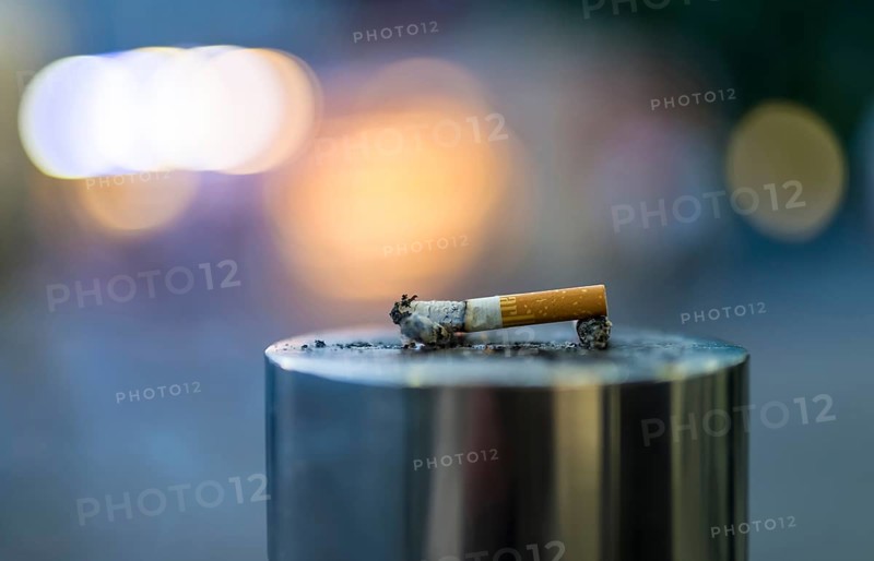 Discarded cigarette butt on metal post