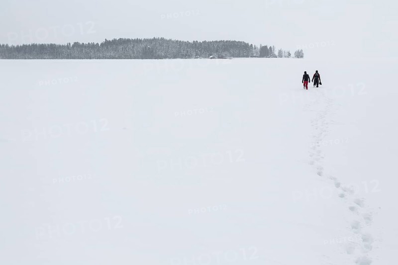 Two people walking over a frozen lake in the Arctic Circle