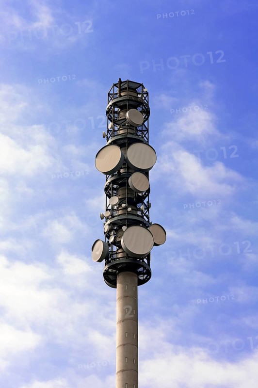 Transmission tower against cloudy sky