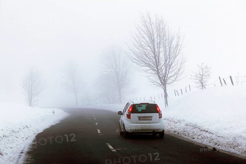 Car on a country road in a snow-covered landscape