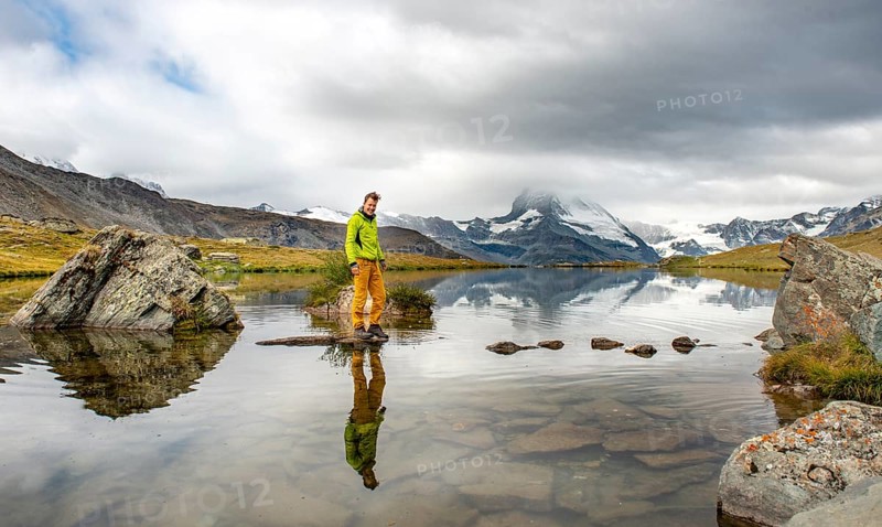 Hiker walks over stones in the water
