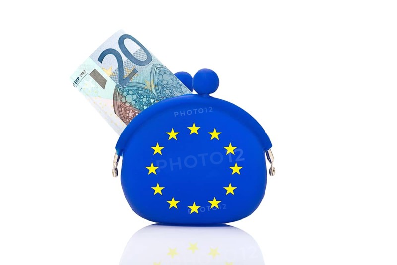 20 euro bill sticking out of a blue purse with euro-stars