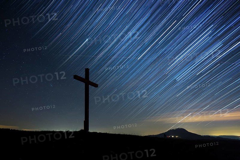 Summit cross on Bisberg Mountain with a starry sky
