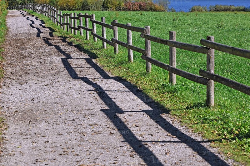 Fence with a shadow along the promenade path