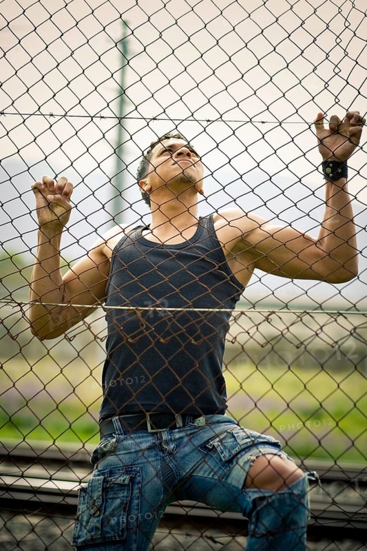 Young man climbing a fence