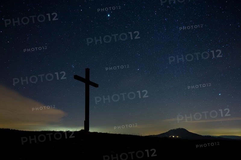 Summit cross on Bisberg Mountain with a starry sky