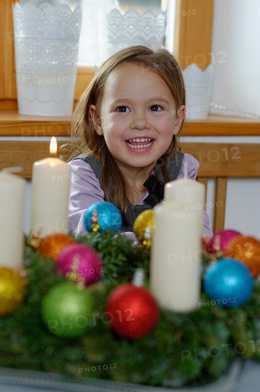 Girl enjoying the first lit candle on the Advent wreath