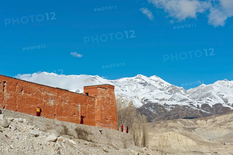 Red wall of a building with monks
