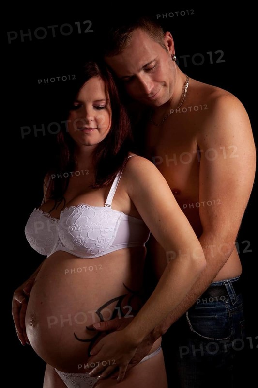 Man hugging his pregnant wife from behind