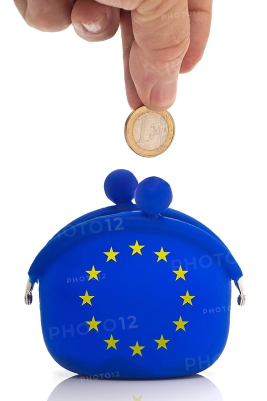Hand dropping a euro coin in a blue purse with euro-stars