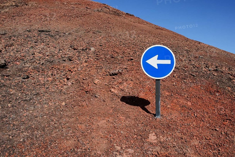 Blue sign with a white arrow pointing left