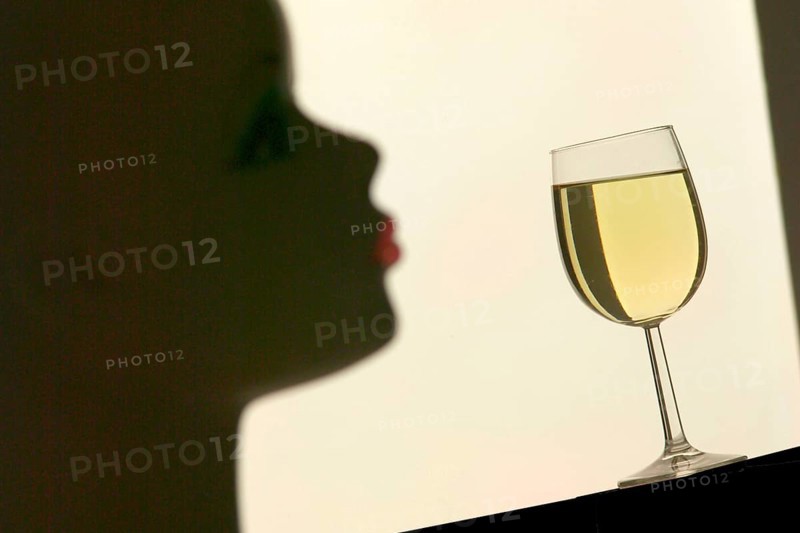 Silhouette in front of a glass with white wine