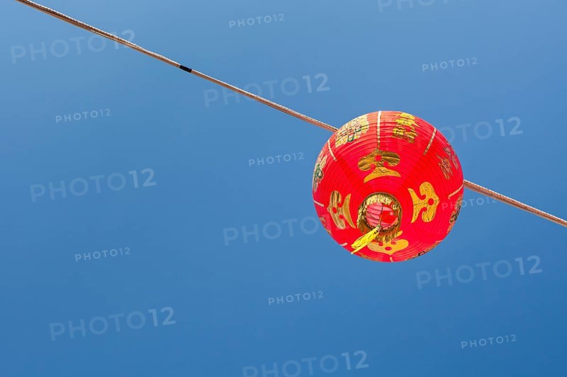 Red Chinese New Year lantern against blue sky