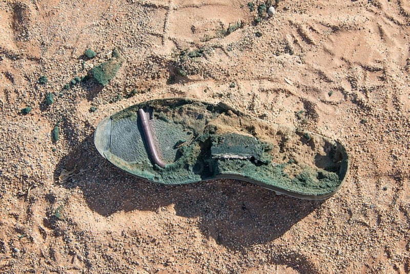 Sole of an old shoe lying in the sand