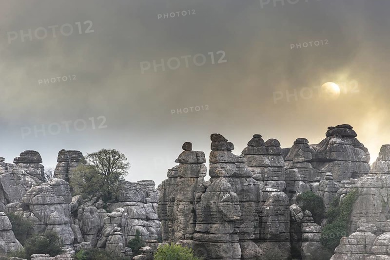 Bizarre limestone rock formations with the sun and fog