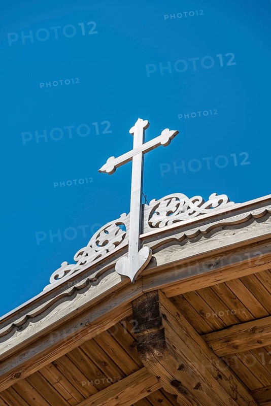 Crucifix on a wooden roof against a blue sky
