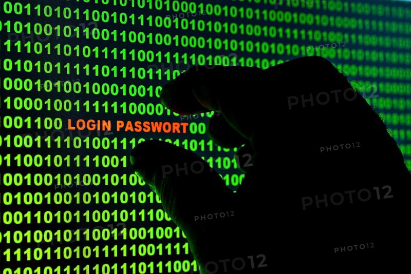 Hand reaching for the words 'Login Passwort' in a binary code