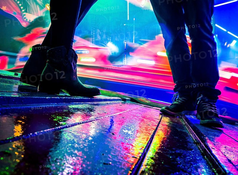 Legs of two people at a funfair