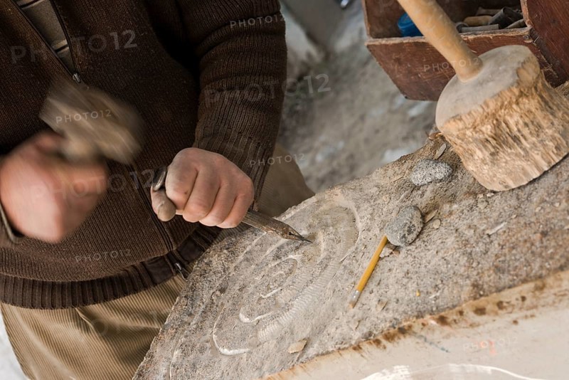 Sculptor chisels the stone