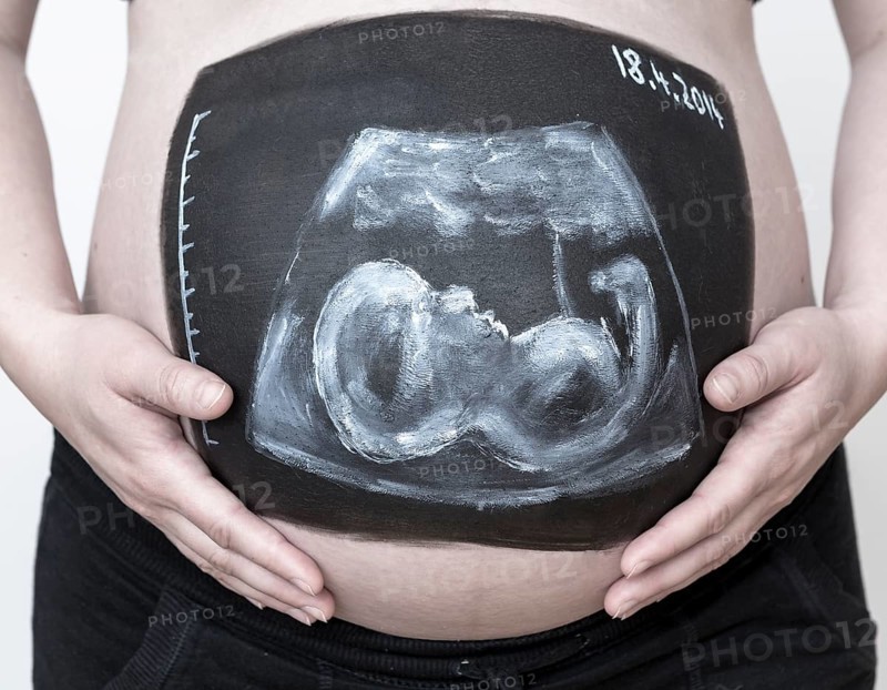 Pregnant woman with a body paint of an ultrasound image on her belly