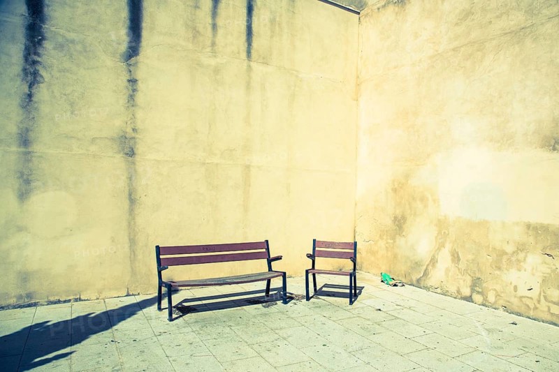 Chair and bench in front of house wall