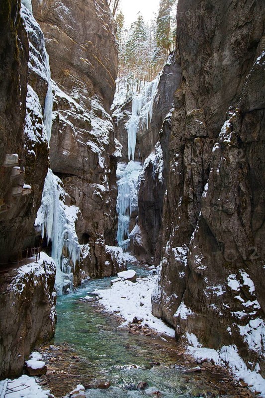 Icy gorge with a mountain stream and steep rock walls
