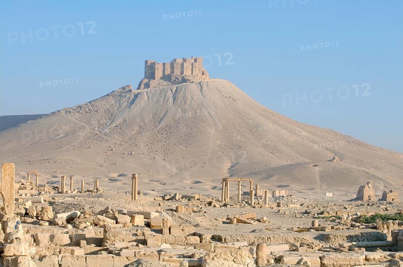The ruins of the ancient city Palmyra in front of a medieval fortress