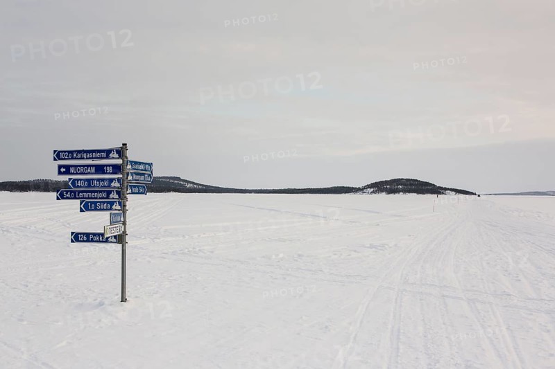Sign post on frozen over Lake Inari