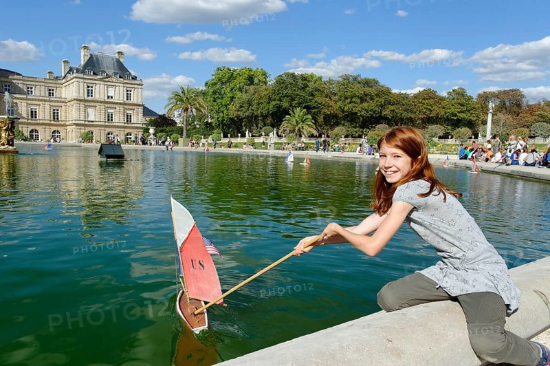 Girl playing with ship at the pond of the Palais du Luxembourg