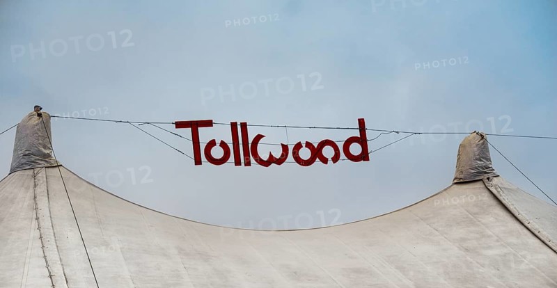 Sign 'Tollwood' above a tent roof