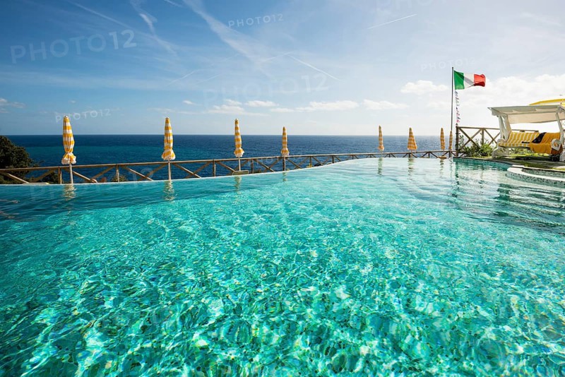 Swimming pool and the Mediterranean with the flag of Italy