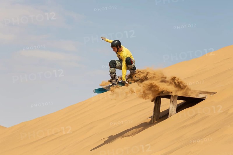 Sand boarding in the dunes of the Namib Desert
