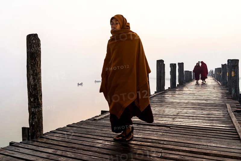 Monks walking on a teak bridge