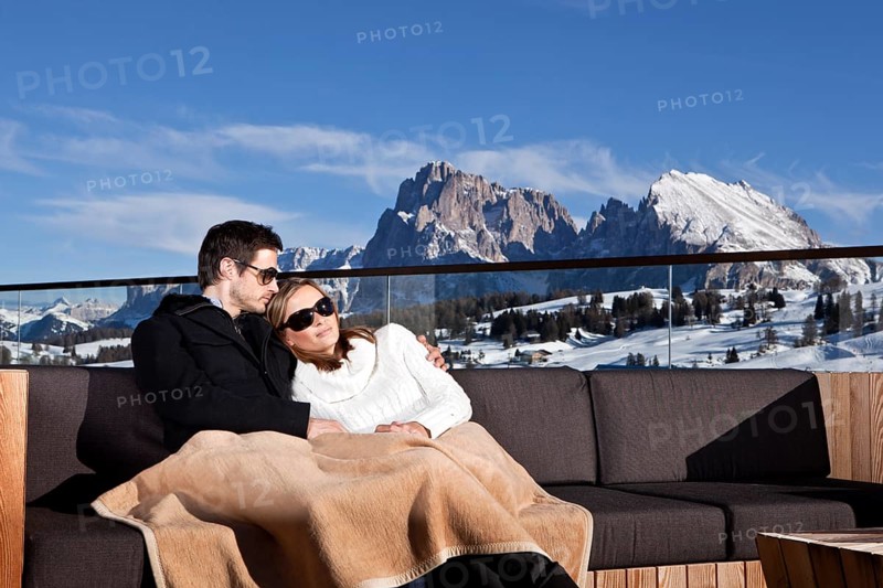 Man and woman sitting on a couch outdoors
