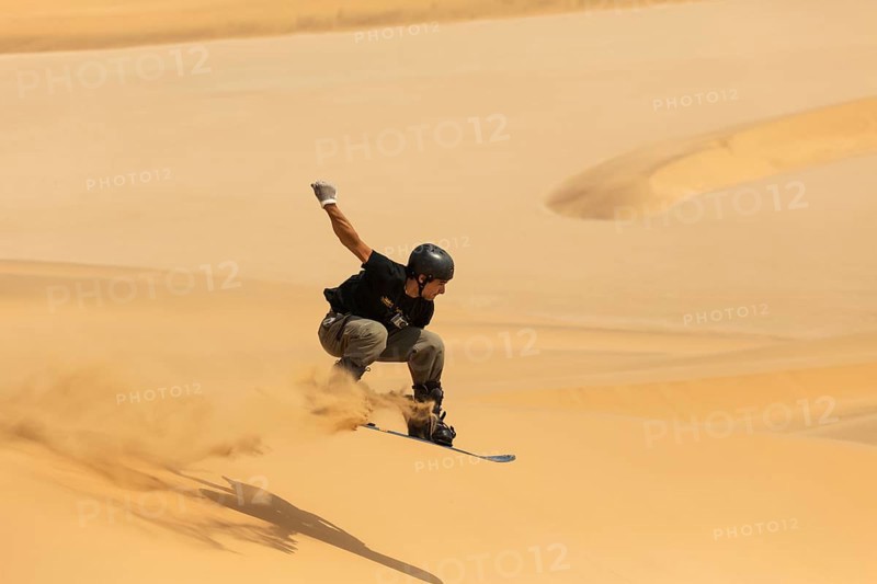 Sand boarding in the dunes of the Namib Desert