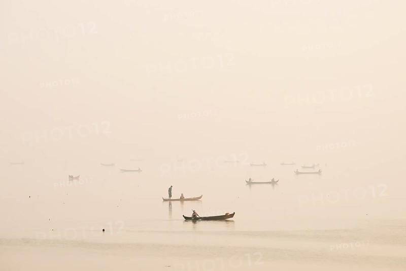 Fishermen in their boats in the morning light