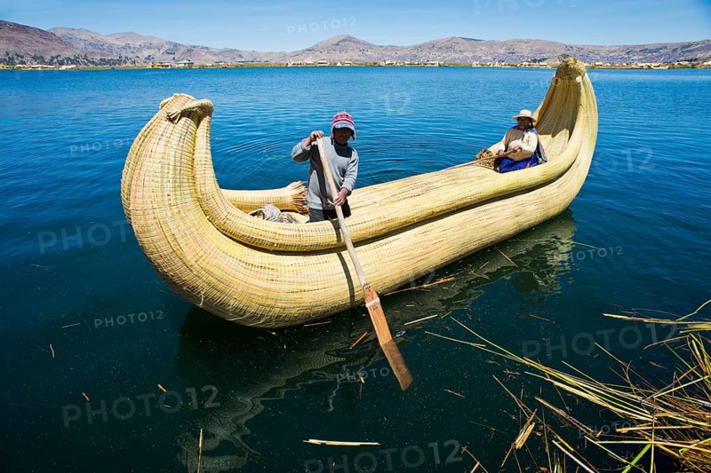 Two local in a traditional rowing boat of Totora reed on Lake Titicaca