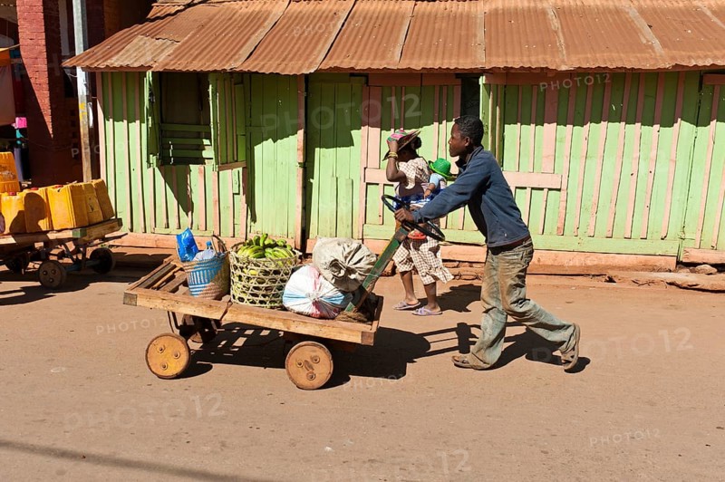 Man pushes goods on a home-made cart