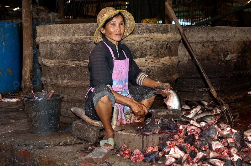 Woman chopping fish at the fish market