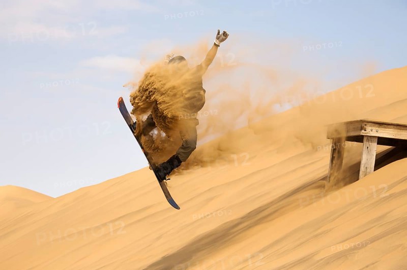 Sand boarding in the dunes of the Namib Desert