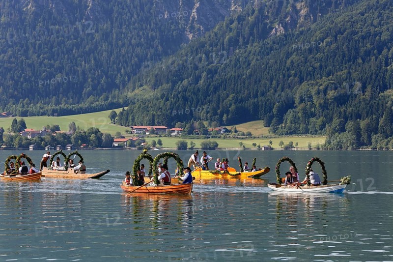Locals wearing traditional costumes in decorated wooden Platte boats